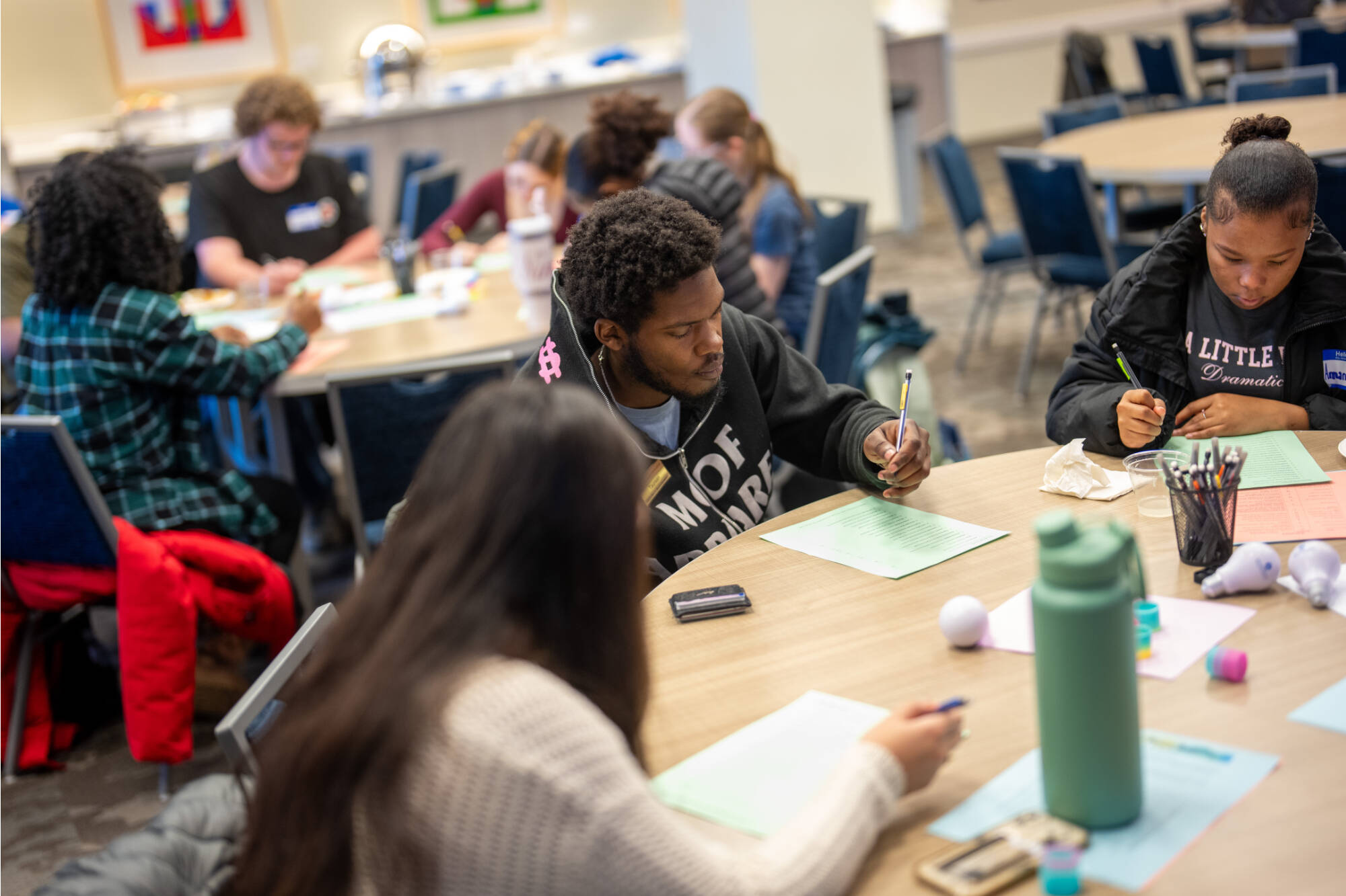 Thompson & Charter Scholars writing their points down  during a leadership series session.